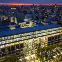 Aerial view of the Universidad Argentina de la Empresa (UADE) campus building illuminated at dusk in Buenos Aires, Argentina.