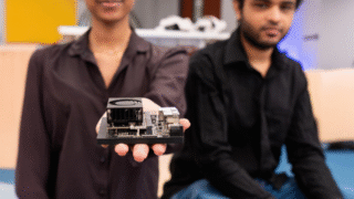 Two students presenting an edge AI device prototype in a university innovation lab.